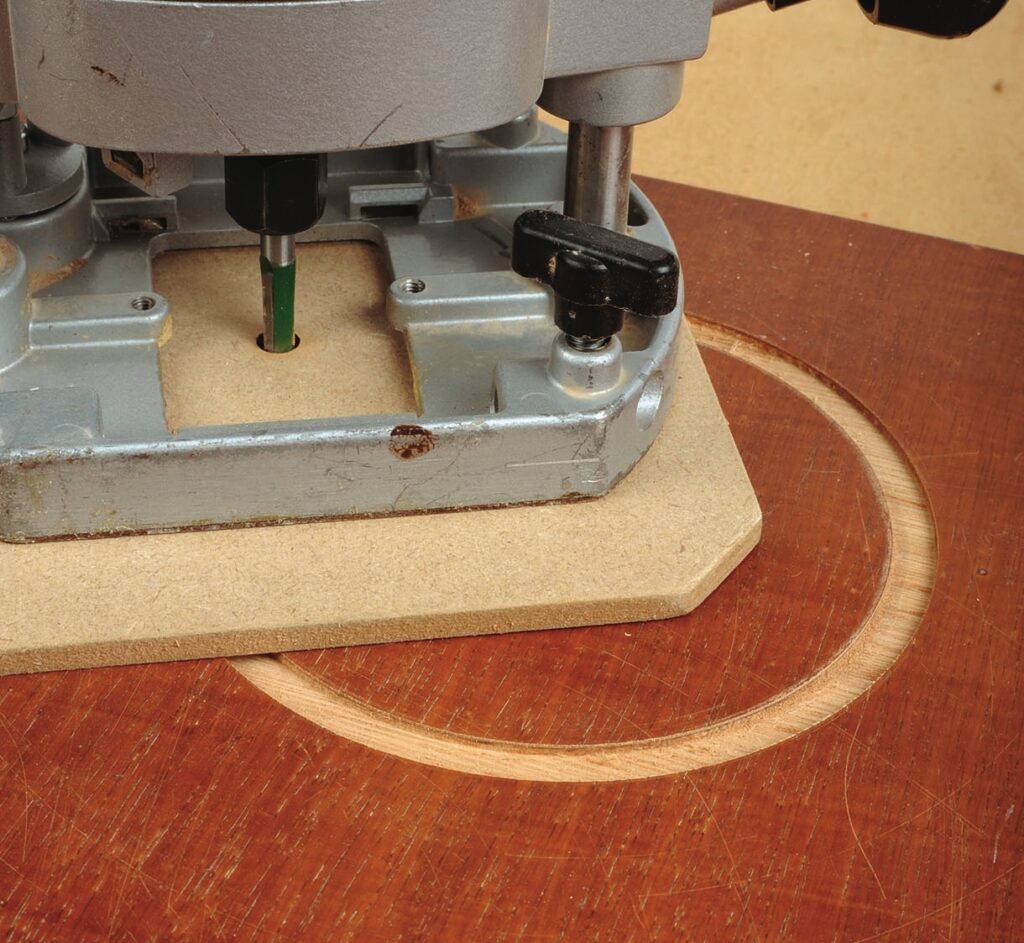 Plunge router cutting circular groove in wood surface.