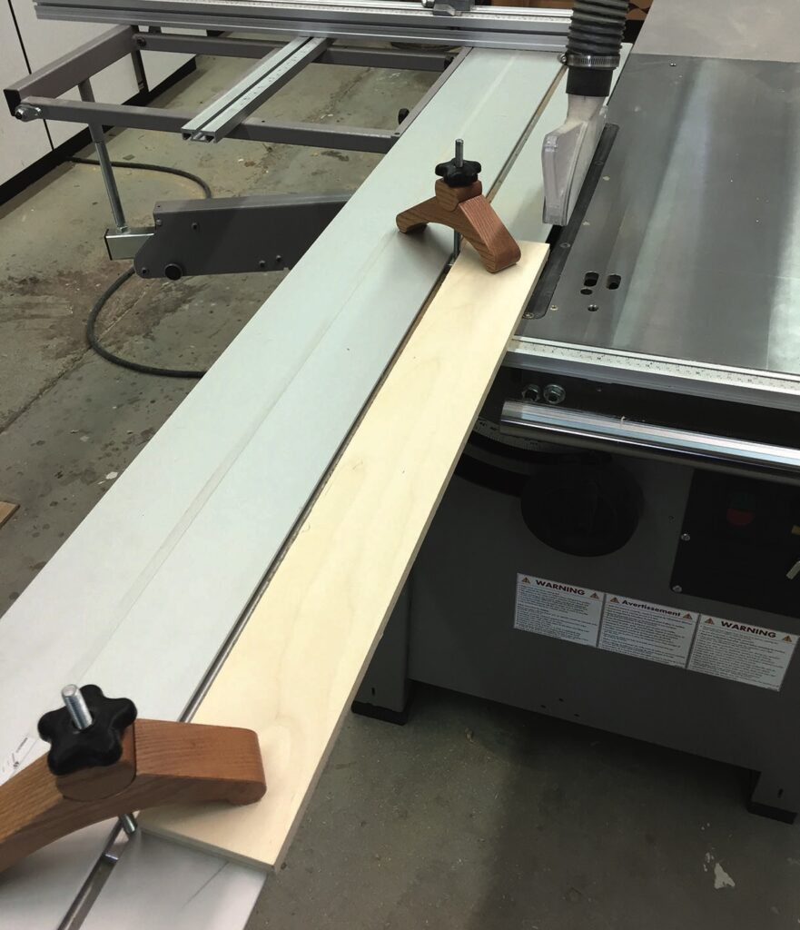 Table saw with wood piece and clamps.