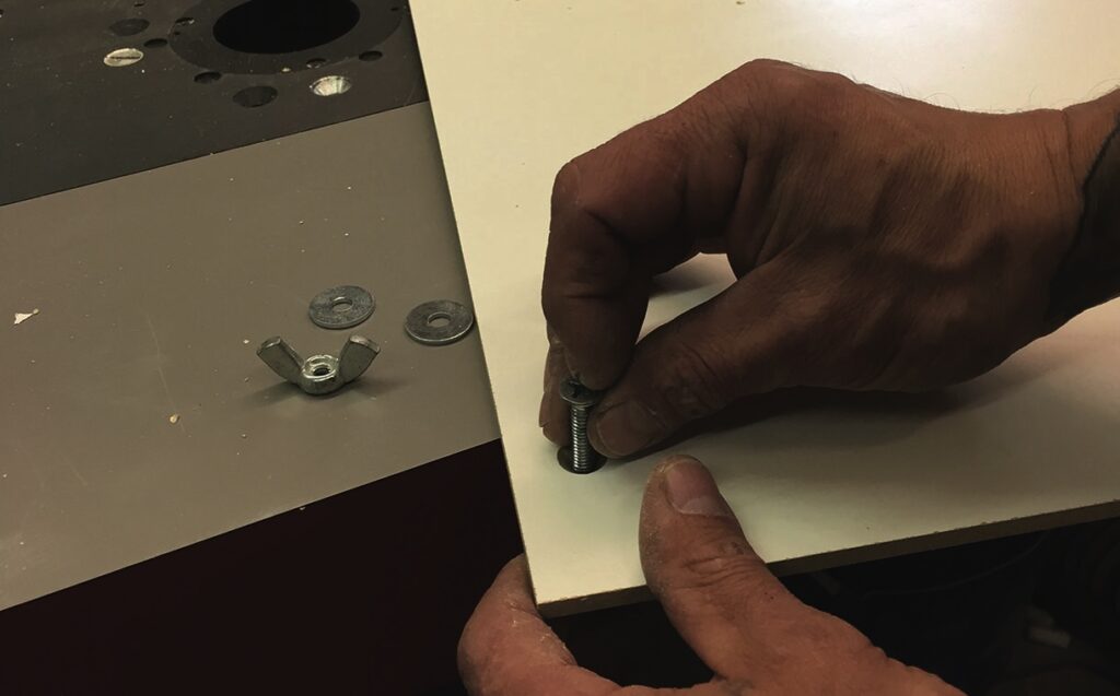 Person assembling furniture using bolts and washers.