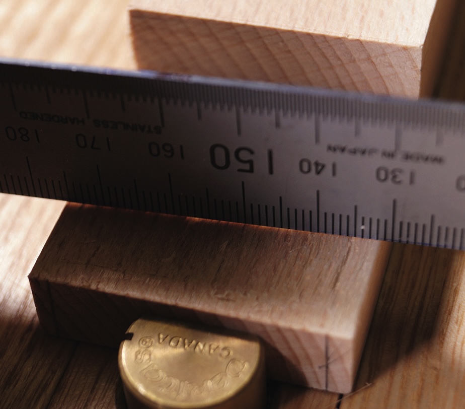 Wood block measured with metal ruler.