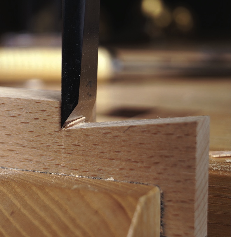 Chisel carving notch in wooden plank