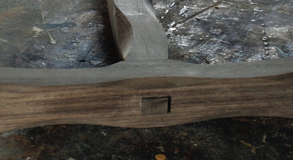 Wooden object with carved mortise joint detail.
