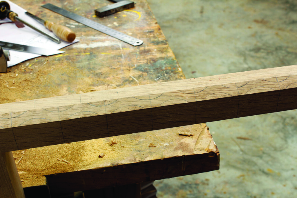 Wooden beam on workshop table with markings.