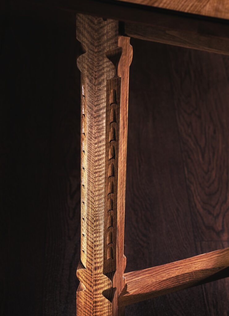 Intricately carved wooden table leg close-up.