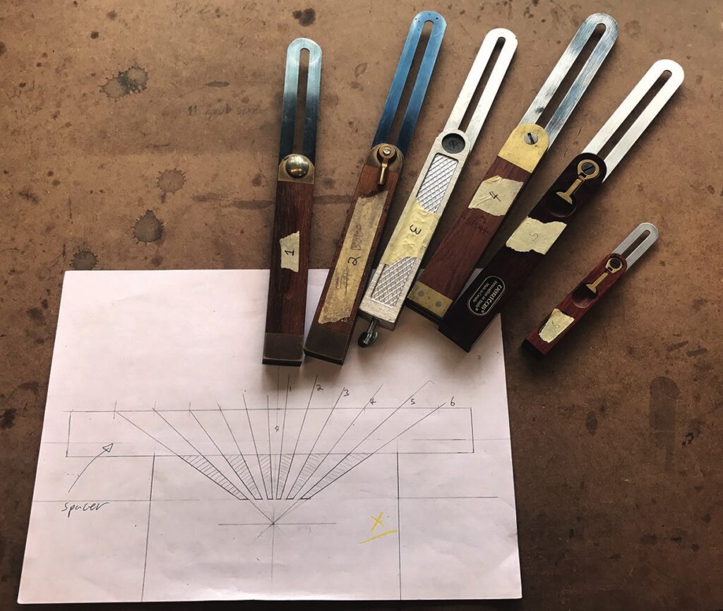Bevel gauges on wooden table with drawing.