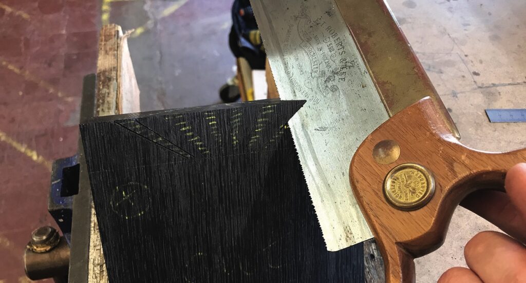 Saw cutting wood with marked lines in workshop.