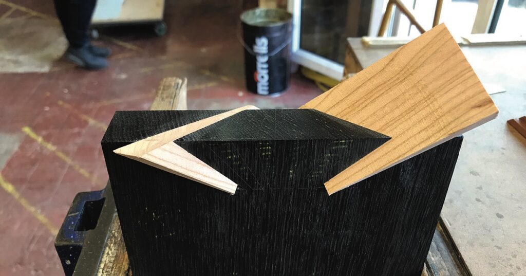 Chevron-shaped wooden joint on black block