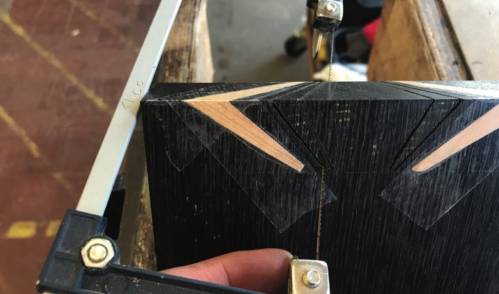 Sawing through a black material block with precision.