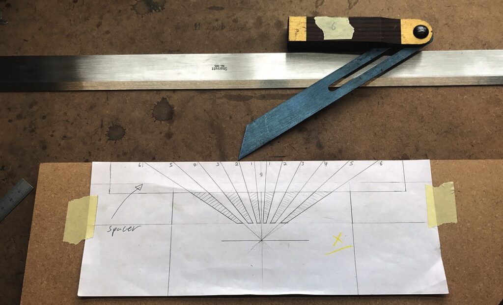Bevel gauge with angle chart drawing on table.