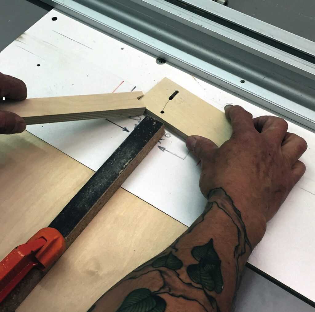 Person assembling wooden frame with hidden joints.
