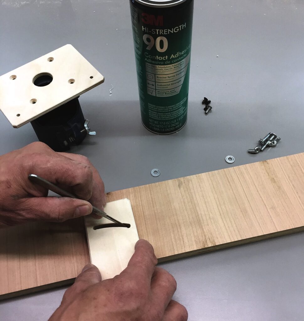 Applying adhesive to wooden piece with tools nearby.