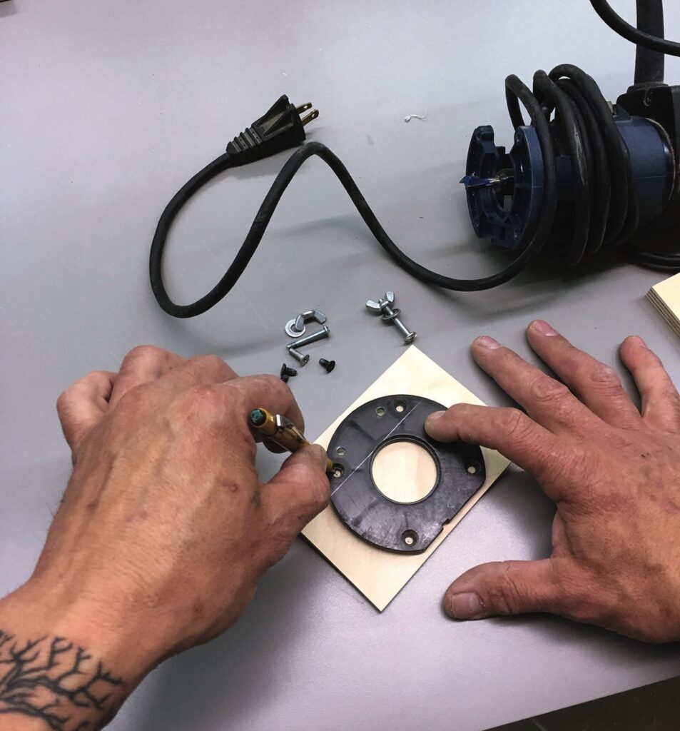 Person assembling electrical component on workbench.