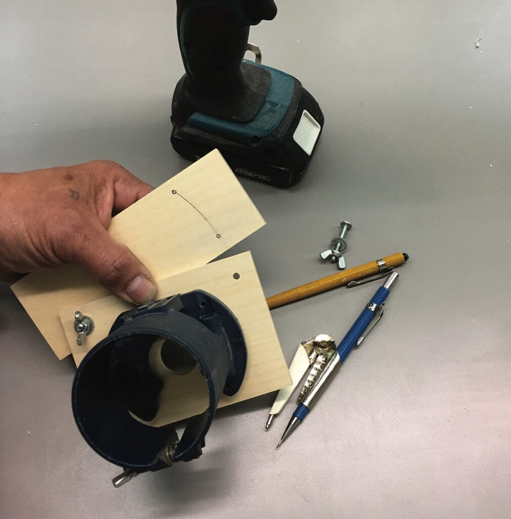 Hand holding woodworking tools and templates.