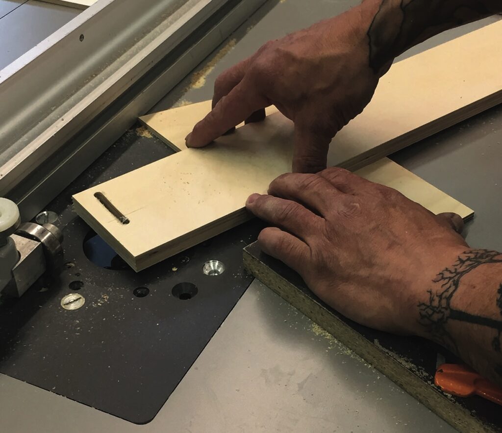 Person cutting wood on a table saw.