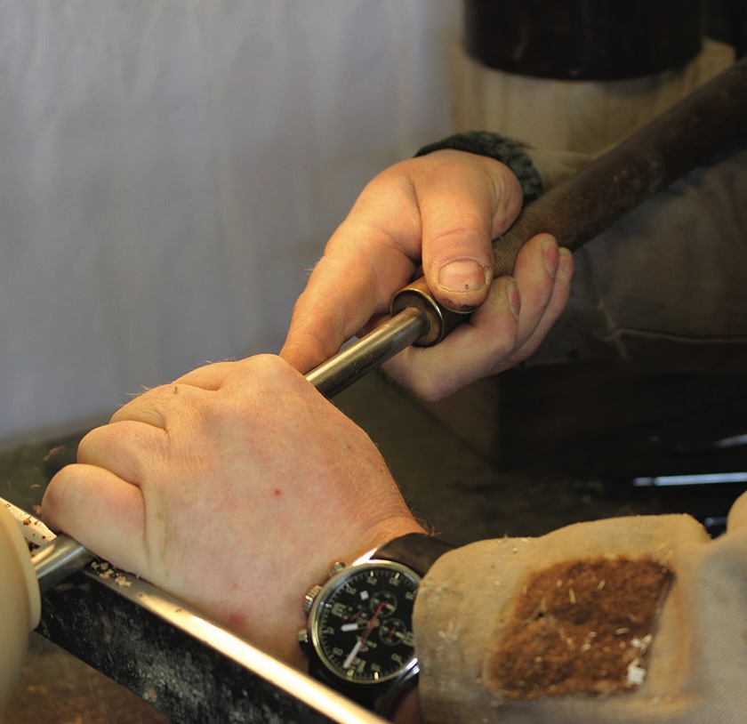 Woodturning with chisel on lathe by craftsman