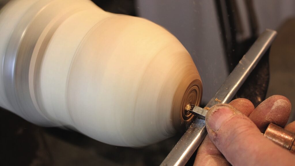 Woodturning process on a lathe with chisel