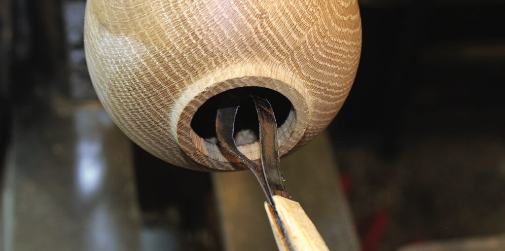 Woodturning tool hollowing a wooden bowl