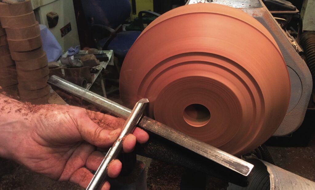 Craftsman shaping wood on a lathe.