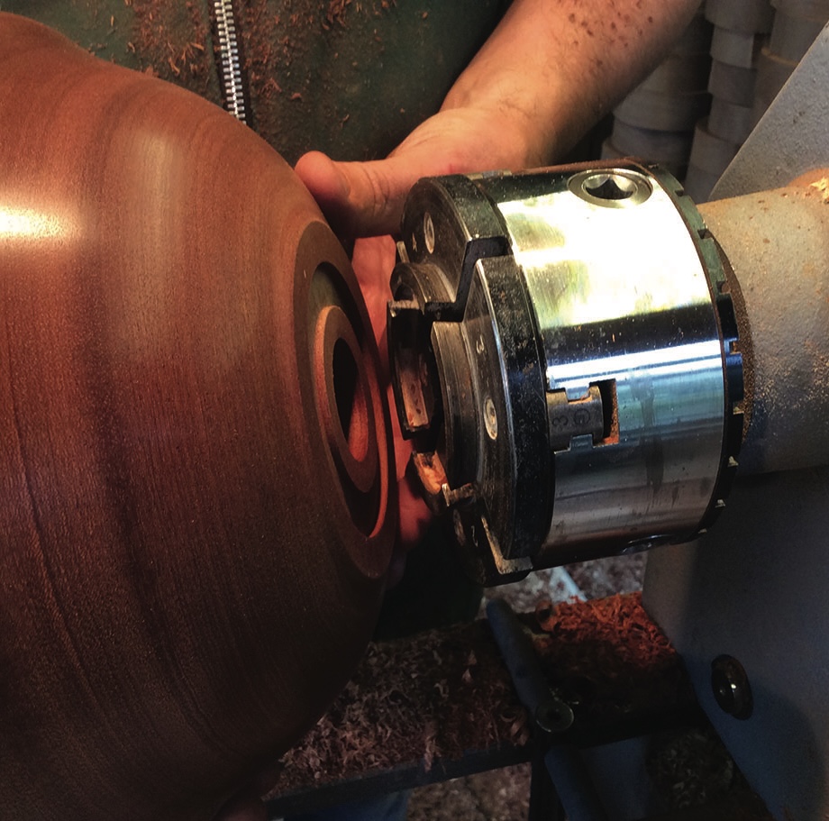 Woodturning on a lathe, creating wooden bowl.