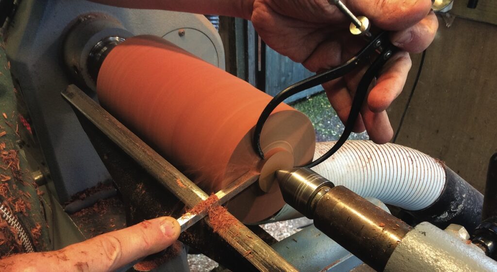 Woodturning on a lathe with measuring tool