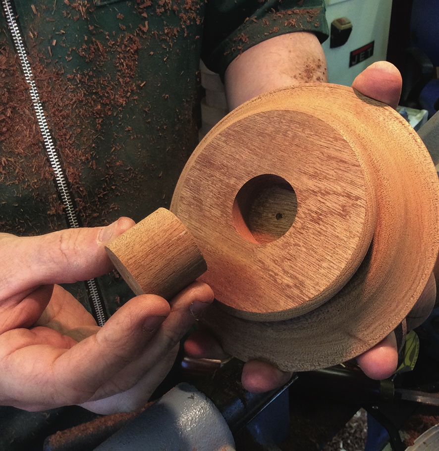Woodturning: hands holding crafted wooden pieces.