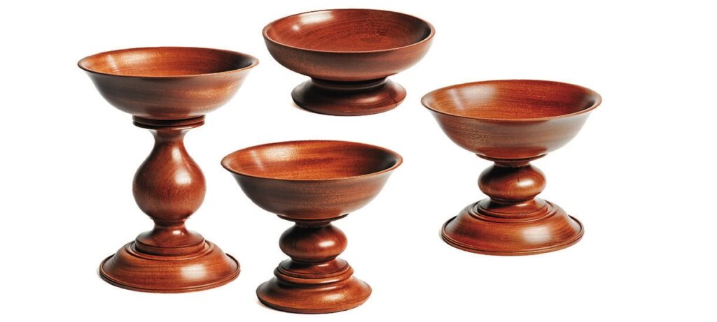 Four wooden pedestal bowls in various sizes
