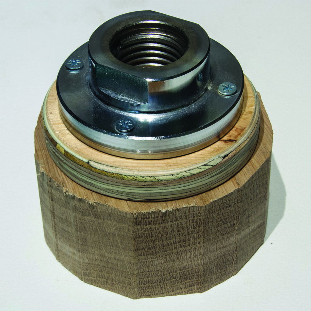 Metal pipe fitting attached to wooden block