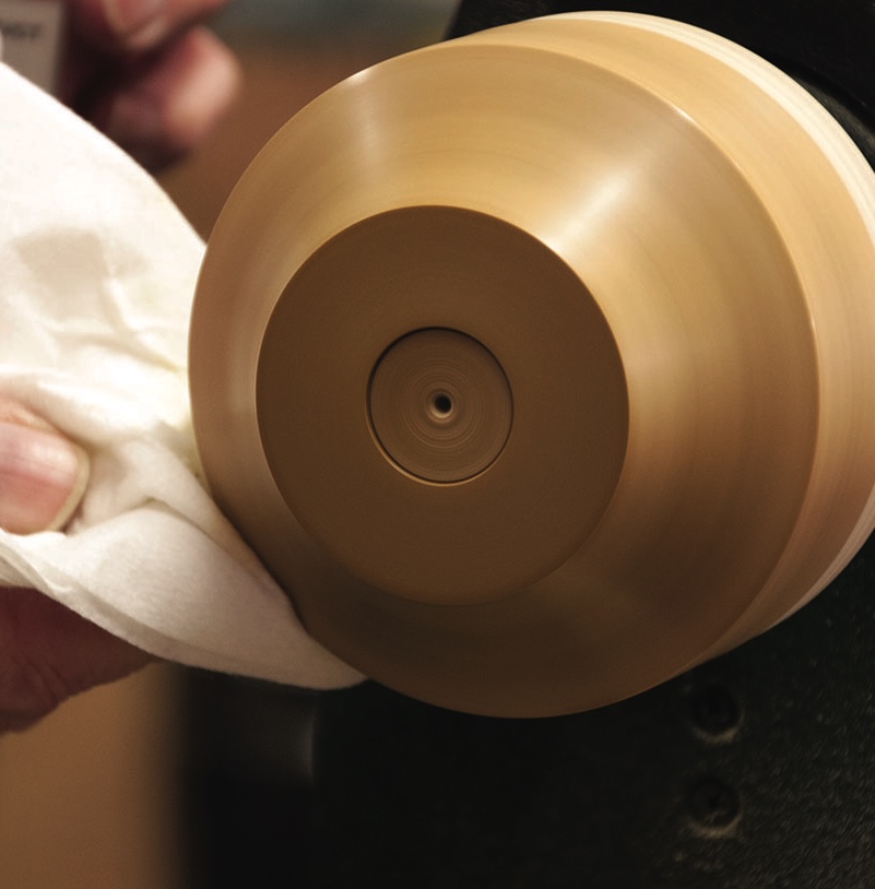 Wood being polished on lathe
