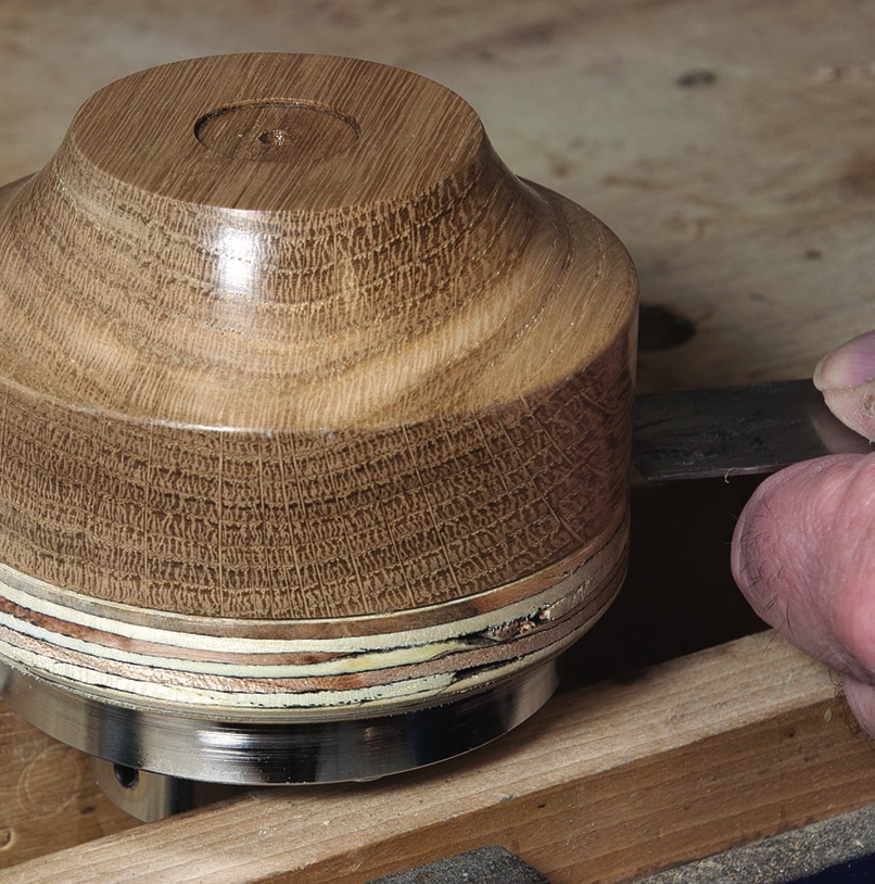 Carving a wooden bowl on a lathe.