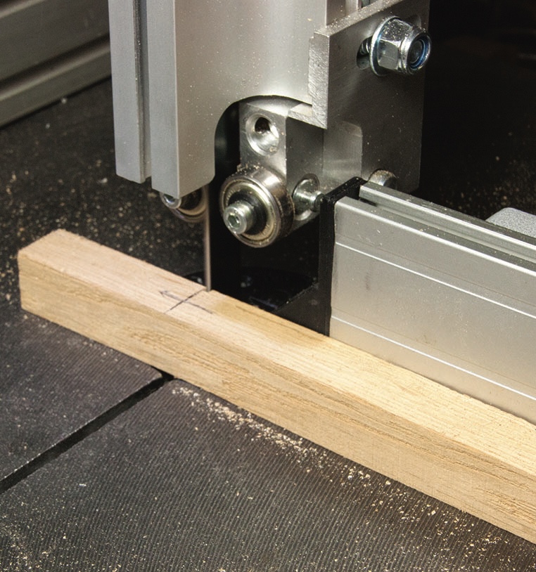 Close-up of metal bandsaw cutting wood
