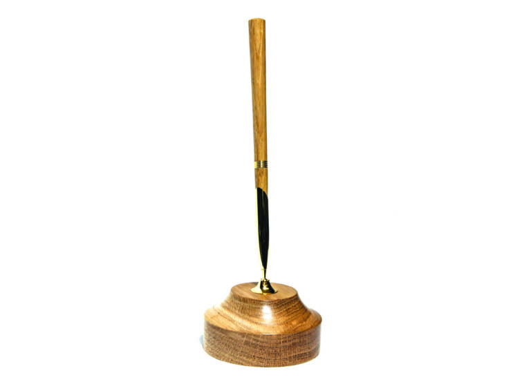 Wooden pen in a matching holder on white background.