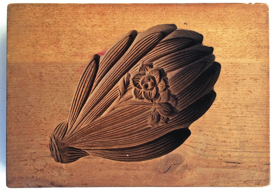 Carved wooden flower design for block printing.