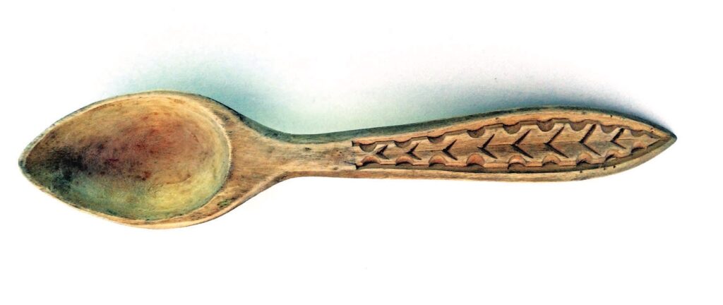 Carved wooden spoon with intricate design.