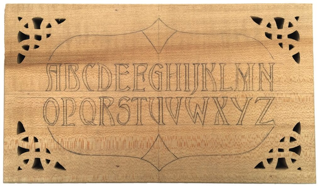 Wooden panel with carved decorative alphabet.