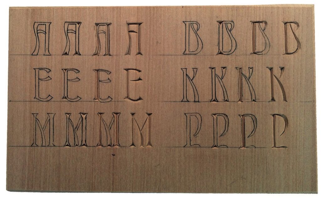 Woodblock showing carved alphabet letters A, B, E, K, M, P.