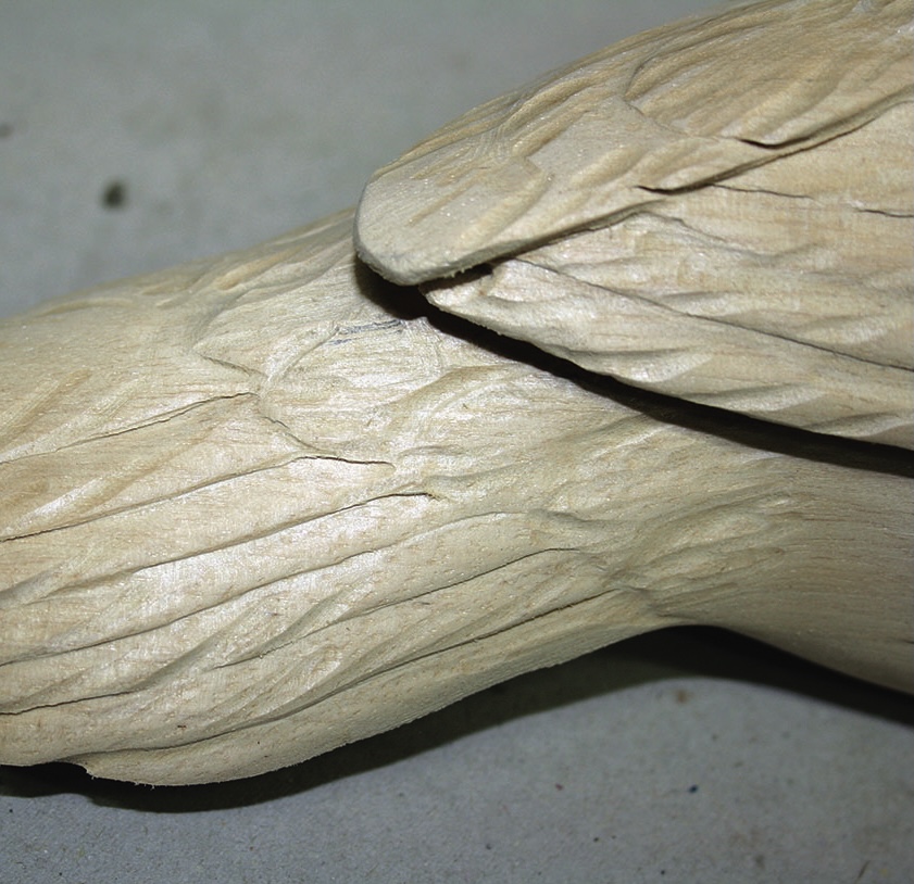 Close-up of carved wooden bird sculpture detail.