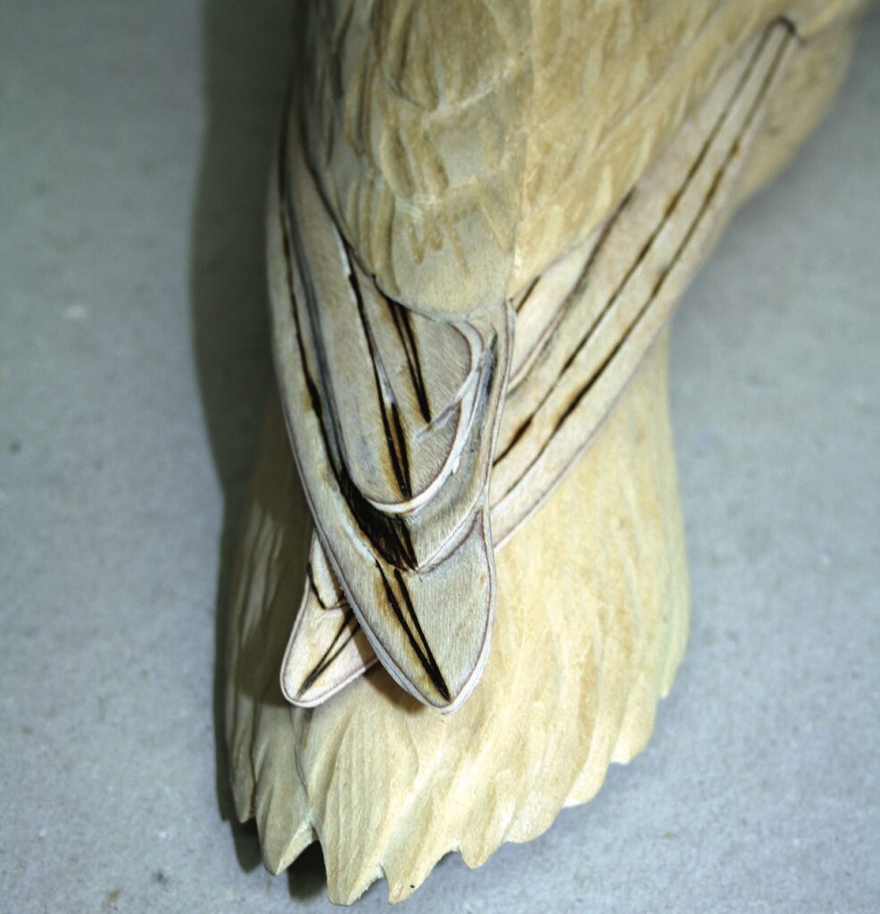 Close-up of intricately carved wooden bird tail