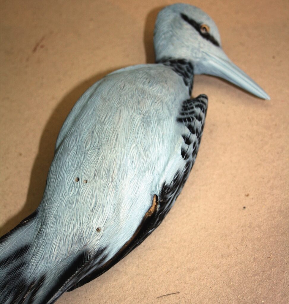 Lifelike heron sculpture on display table.