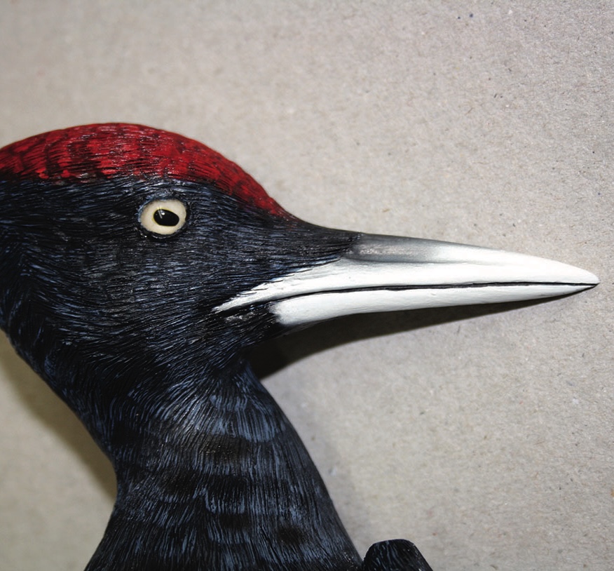 Close-up of a black woodpecker sculpture.