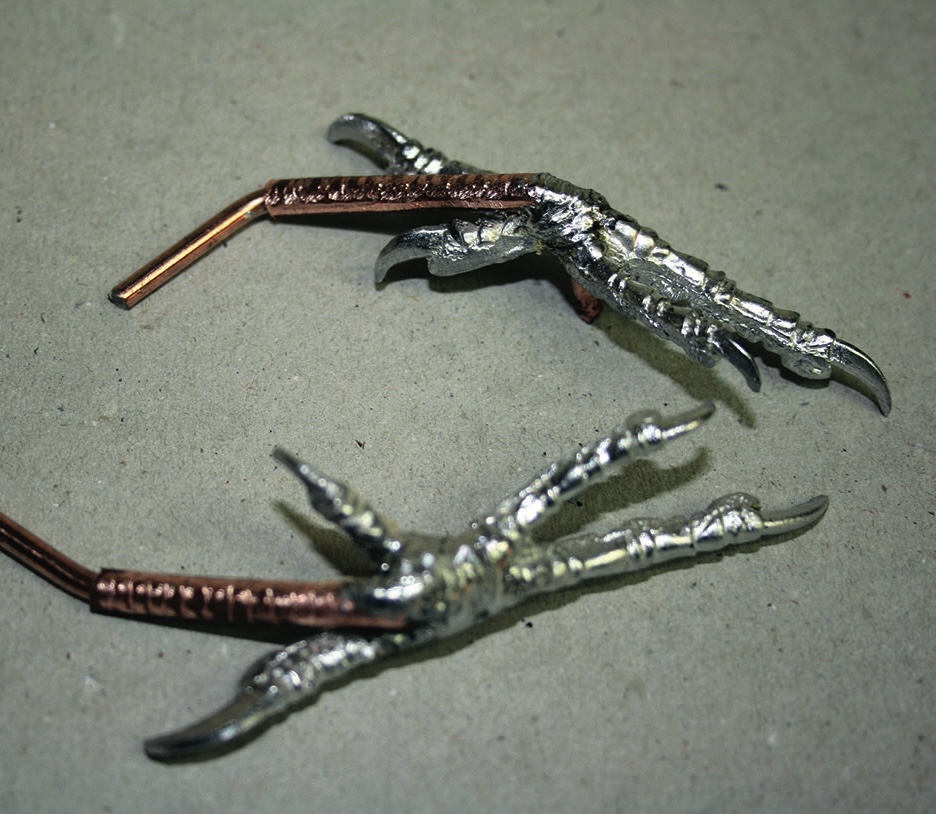 Metal bird claw sculptures on display