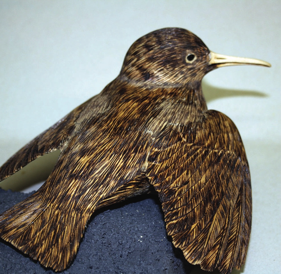 Wooden carved bird on stone base