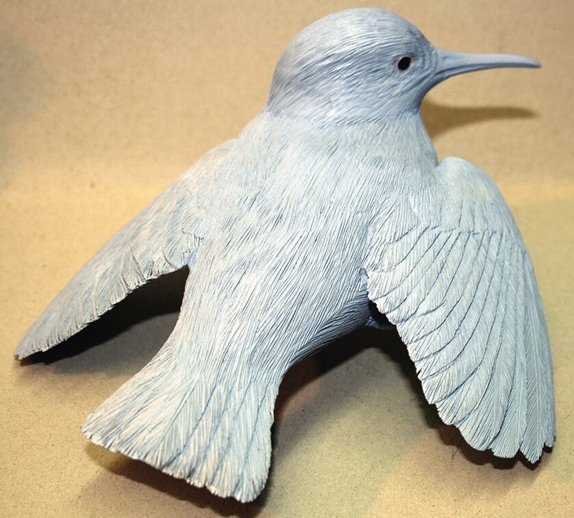 Grey bird sculpture with outstretched wings.