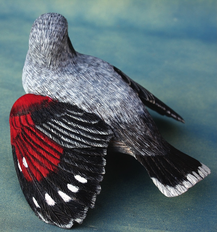 Intricate grey and red bird embroidery art.