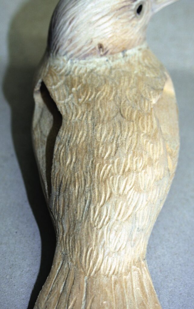 Wooden bird sculpture with carved details.
