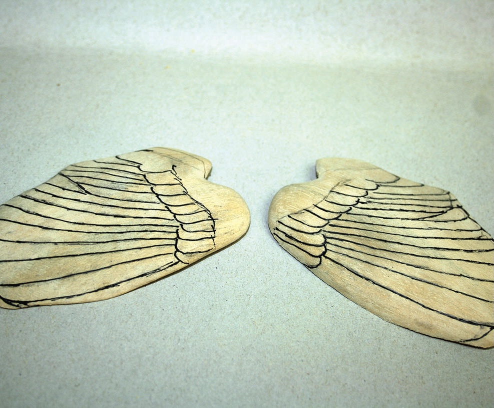 Wooden angel wings on a light background.