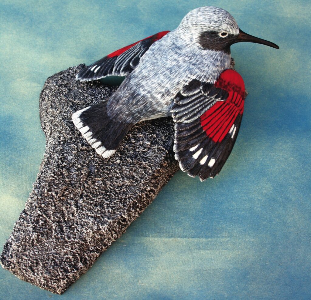 Detailed bird figurine with grey and red wings.