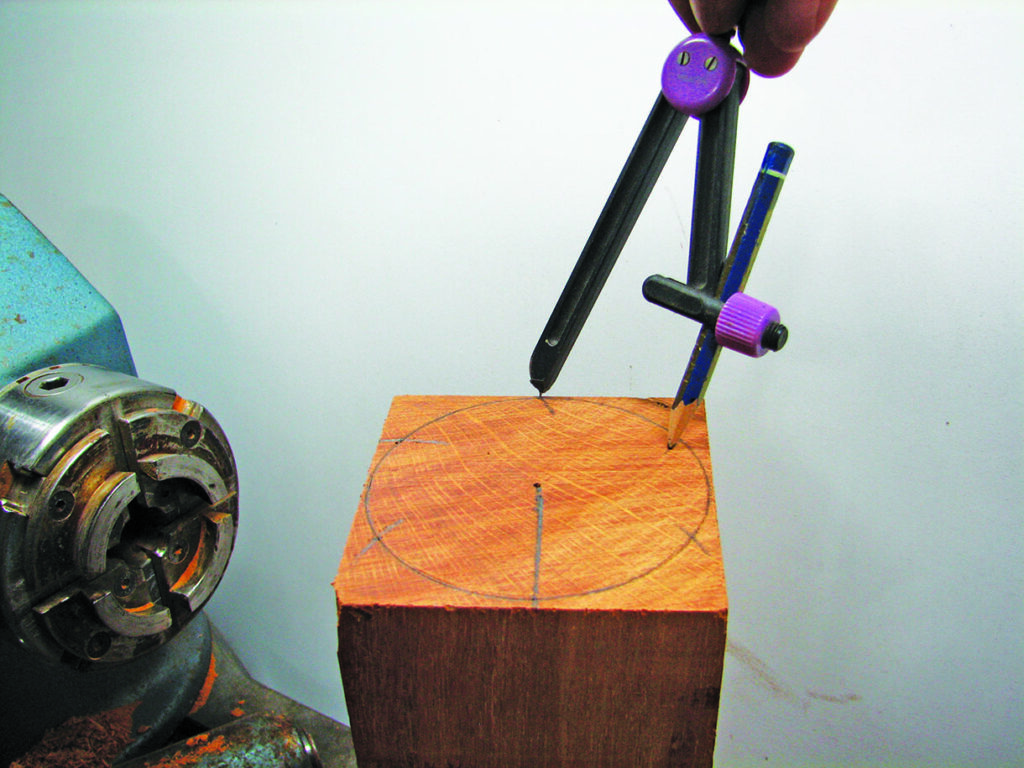 Drawing circle on wood with compass near lathe.