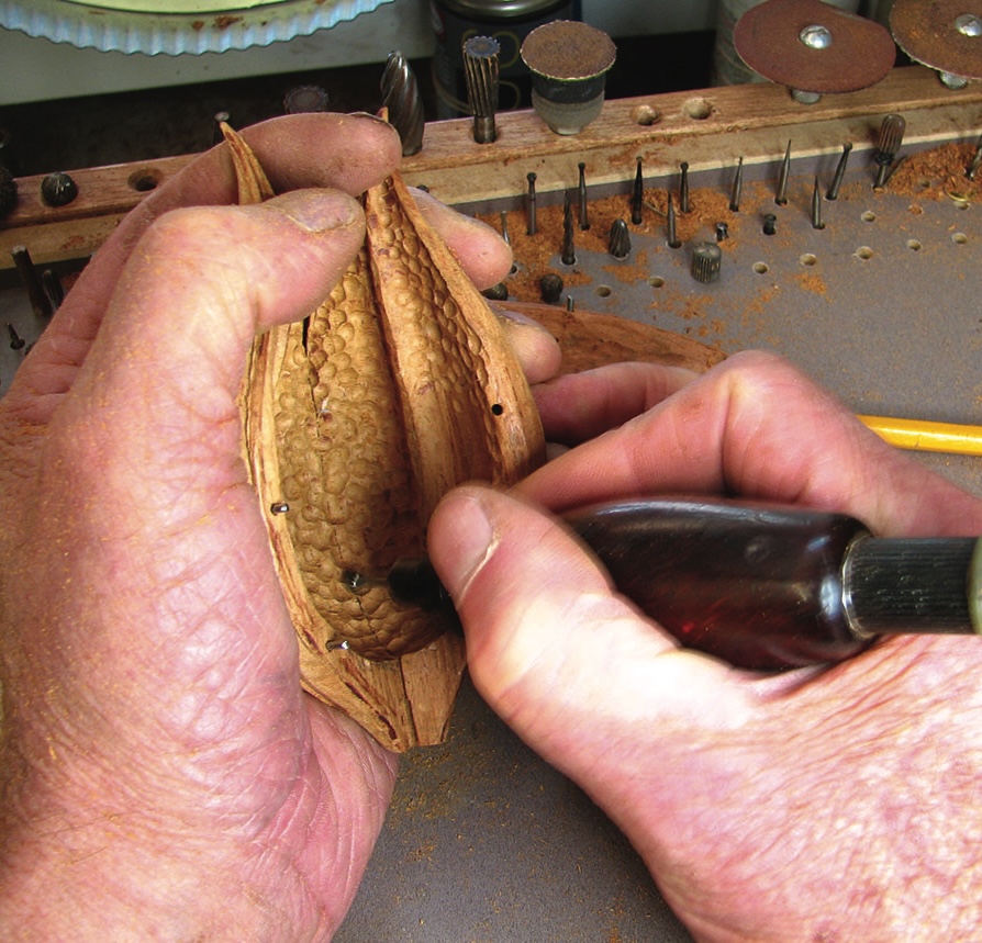 Carving wood intricately with hand tools.
