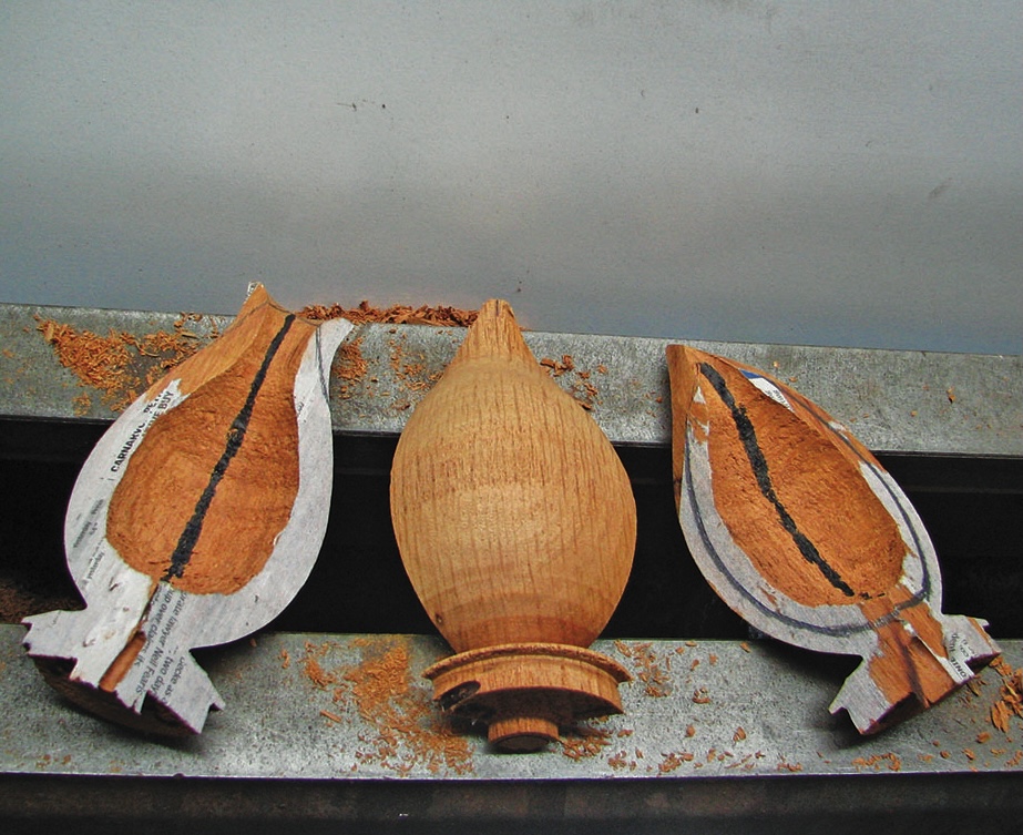 Carved wooden finials with paper templates.