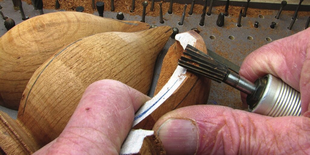Hands carving wood with rotary tool
